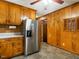 Efficient kitchen with wood cabinets, stainless steel refrigerator, and functional layout, ready for your personal updates at 605 Mace Rd, Mebane, NC 27302