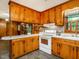 Cozy kitchen featuring wood cabinets, white appliances, and ample counter space, perfect for everyday cooking at 605 Mace Rd, Mebane, NC 27302