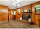 Comfortable living area boasting a brick fireplace, cozy wood paneling, and access to additional rooms at 605 Mace Rd, Mebane, NC 27302