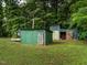 Exterior view of green outbuildings with rustic doors, ideal for storage or workshop space at 605 Mace Rd, Mebane, NC 27302
