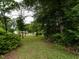 Spacious and expansive backyard featuring a mix of open lawn and wooded areas, for recreation and relaxation at 605 Mace Rd, Mebane, NC 27302
