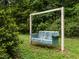 Vintage metal porch swing in a green yard with lush surroundings offering a relaxing outdoor space at 605 Mace Rd, Mebane, NC 27302