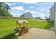 Spacious backyard featuring lush green grass, a playhouse, and a charming patio area at 672 Millers Mark Ave, Wake Forest, NC 27587