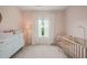 Bright Bedroom featuring a crib, white dresser, neutral carpet, and large window with sheer curtains at 672 Millers Mark Ave, Wake Forest, NC 27587