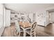Open dining area with stylish table and chairs, flowing into a kitchen with white cabinets and modern appliances at 672 Millers Mark Ave, Wake Forest, NC 27587