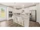Modern white kitchen with stainless steel appliances, granite countertops and a stylish island at 672 Millers Mark Ave, Wake Forest, NC 27587