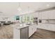 Open-concept kitchen with stainless appliances and spacious island, seamlessly flowing into the dining and living areas at 672 Millers Mark Ave, Wake Forest, NC 27587