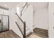 Bright, carpeted stairway with white railings and wooden banister, adjacent to a stainless steel refrigerator and coat rack at 672 Millers Mark Ave, Wake Forest, NC 27587