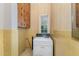 Vintage laundry room with yellow tiles, cabinets, and a white washing machine at 6720 Dwight Rowland Rd, Willow Springs, NC 27592