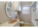 Bathroom with unique sink, framed oval mirror, shuttered window and vintage tile floor at 75 Hartwell Cir, Lillington, NC 27546