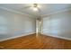 Bright bedroom features gleaming hardwood floors, neutral paint and ceiling fan at 75 Hartwell Cir, Lillington, NC 27546
