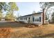 Well-maintained single-story home featuring a brick chimney, and manicured lawn with mature trees at 75 Hartwell Cir, Lillington, NC 27546