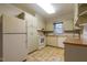 Classic kitchen featuring white cabinets, laminate countertops, and neutral backsplash and tile flooring at 75 Hartwell Cir, Lillington, NC 27546