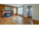 Inviting living room with wood-paneled walls, a brick fireplace, and hardwood floors at 75 Hartwell Cir, Lillington, NC 27546