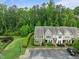 Aerial view of townhome complex with well-maintained landscaping, parking, and surrounding greenery at 7871 Allscott Way, Raleigh, NC 27612