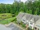 Aerial view of townhomes, mature trees, parking and small pond at 7871 Allscott Way, Raleigh, NC 27612