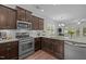 Modern kitchen features stainless steel appliances, granite countertops, and dark wood cabinetry at 7871 Allscott Way, Raleigh, NC 27612
