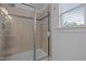Modern shower with tiled walls and sliding glass door at 7871 Allscott Way, Raleigh, NC 27612