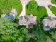Aerial view of a home with an inviting deck surrounded by mature trees and landscaped gardens at 7929 Pine Timber Dr, Raleigh, NC 27613