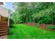 Serene backyard view with lush greenery, mature trees, and a charming wooden fence at 7929 Pine Timber Dr, Raleigh, NC 27613