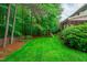 Expansive backyard featuring a play set, lush lawn, privacy fence, and mature trees at 7929 Pine Timber Dr, Raleigh, NC 27613