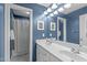 Stylish bathroom featuring double sinks, blue walls, and a shower/tub combo at 7929 Pine Timber Dr, Raleigh, NC 27613