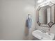 Clean half bath with a decorative mirror and a pedestal sink at 7929 Pine Timber Dr, Raleigh, NC 27613