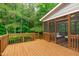 Expansive wooden deck leads to a screened-in porch, surrounded by a lush, wooded landscape at 7929 Pine Timber Dr, Raleigh, NC 27613