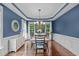 Elegant dining room featuring blue walls, hardwood floors, and a chandelier above a wooden table at 7929 Pine Timber Dr, Raleigh, NC 27613