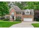 Charming two-story brick home featuring black shutters, a manicured lawn, and an attached two-car garage at 7929 Pine Timber Dr, Raleigh, NC 27613