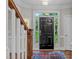 Inviting foyer with hardwood floors, staircase and a view to the exterior through a glass-panelled front door at 7929 Pine Timber Dr, Raleigh, NC 27613