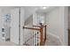 Upstairs hallway featuring neutral walls, white trim, and carpeted floors with wood banister at 7929 Pine Timber Dr, Raleigh, NC 27613