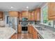 Well-lit kitchen showcases wood cabinets, stainless steel appliances, and marble countertops at 7929 Pine Timber Dr, Raleigh, NC 27613