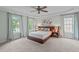 Spacious main bedroom featuring a ceiling fan, large windows and neutral carpet at 7929 Pine Timber Dr, Raleigh, NC 27613