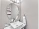 Elegant powder room with modern vessel sink, stylish faucet, round mirror, and tile accent wall at 8504 Delavan Cir, Raleigh, NC 27613