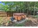Backyard hot tub area, set on gravel, enclosed by a wooden fence and mature trees at 8504 Delavan Cir, Raleigh, NC 27613