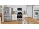 Modern kitchen featuring stainless steel appliances, white cabinetry, and a breakfast bar at 8504 Delavan Cir, Raleigh, NC 27613