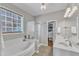Luxurious bathroom featuring a soaking tub, a glass-enclosed shower, and double sinks at 8504 Delavan Cir, Raleigh, NC 27613