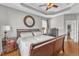 Well-lit main bedroom featuring a tray ceiling, hardwood floors, and neutral decor at 8504 Delavan Cir, Raleigh, NC 27613