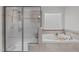 Modern bathroom featuring a glass-enclosed shower and a soaking tub with decorative tiles at 851 Dotson Way, Apex, NC 27523