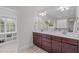 Bright bathroom featuring double vanities, a large mirror, and an open doorway to the closet at 851 Dotson Way, Apex, NC 27523