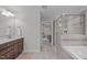 Well-lit bathroom showcasing a glass shower, soaking tub, and a double vanity at 851 Dotson Way, Apex, NC 27523
