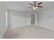 A bright bedroom with a ceiling fan and carpeted flooring leads to an open doorway at 851 Dotson Way, Apex, NC 27523