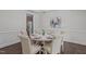 Elegant dining room featuring wainscoting, modern chandelier, and a round table set for a dinner gathering at 851 Dotson Way, Apex, NC 27523