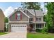 Charming two-story home featuring a stone facade, two-car garage, and a welcoming front porch, surrounded by lush greenery at 851 Dotson Way, Apex, NC 27523