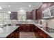 Bright kitchen featuring granite countertops, stainless steel appliances, and cherry wood cabinets at 851 Dotson Way, Apex, NC 27523
