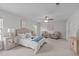 Spacious main bedroom with neutral walls, a ceiling fan, a queen bed, and an inviting sitting area at 851 Dotson Way, Apex, NC 27523