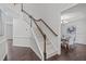 Elegant staircase featuring wood railing and carpeted steps leads to the upper level and dining room at 851 Dotson Way, Apex, NC 27523