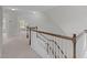 Bright staircase landing with wood railing, carpeted floor, and an open view to another room at 851 Dotson Way, Apex, NC 27523