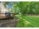View of the deck from the backyard showing a grill and lush lawn at 9 Sandhill Ln, Durham, NC 27713